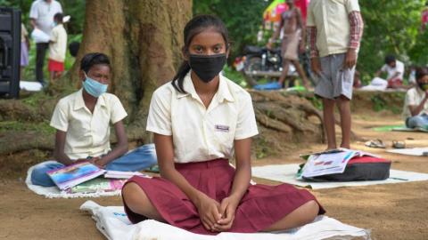 Female student sitting wearing a black mask