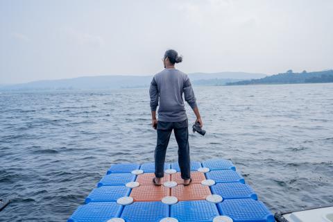 Man posing with camera near river