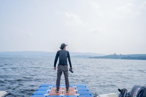 Man posing with camera near river